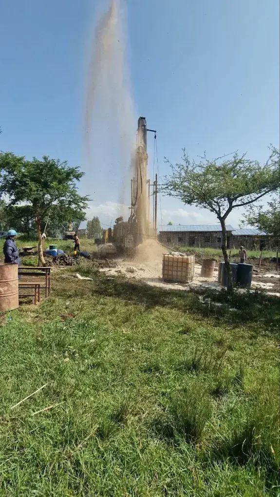 A Liyat rig carrying out well development on a site surrounded by grass and trees